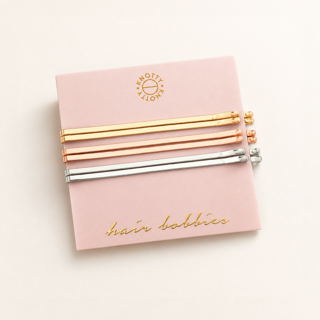 Six metallic hair bobbies in gold, rose gold and rhodium finishes on their pink card